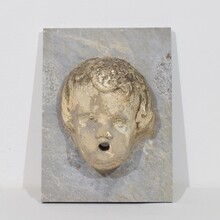 Carved stone cherub fountain head on marble panel, Italy circa 1650-1750
