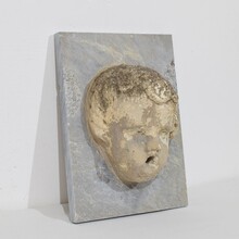 Carved stone cherub fountain head on marble panel, Italy circa 1650-1750