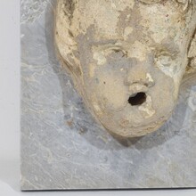 Carved stone cherub fountain head on marble panel, Italy circa 1650-1750