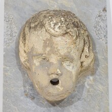 Carved stone cherub fountain head on marble panel, Italy circa 1650-1750